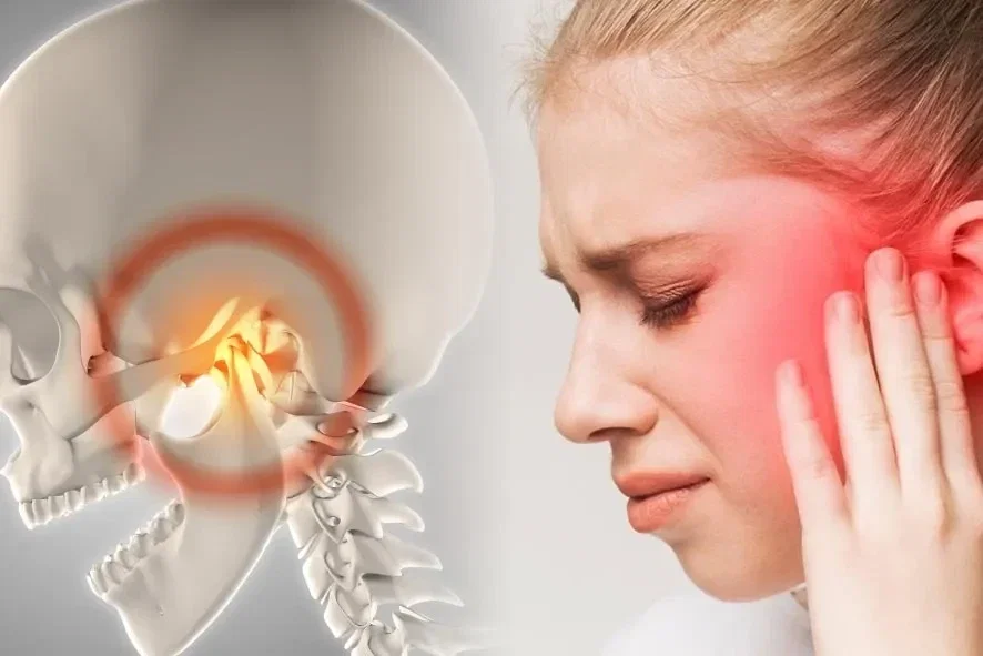 Ilustração da articulação temporomandibular inflamada ao lado de mulher com dor na região do ouvido